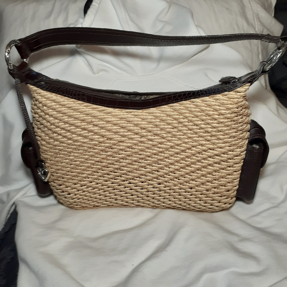Brighton woven handbag with leather trim handle and side pockets.